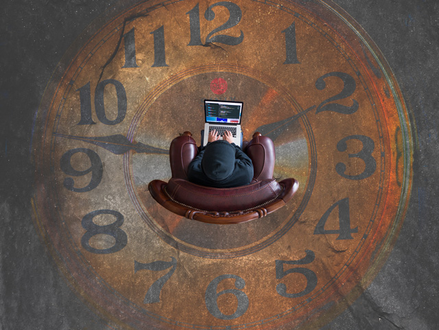 A user sat on the floor with a laptop. A clock is painted on the floor.
