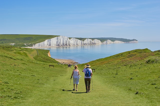 A couple walking towards the Seven Sisters, Sussex, UK